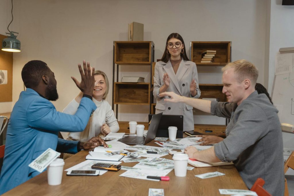 A multicultural team enjoying success during a collaborative business meeting in a modern office.